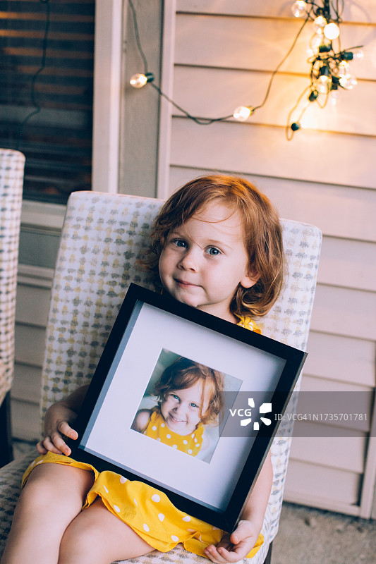 女孩拿着自己的印刷装裱照片图片素材