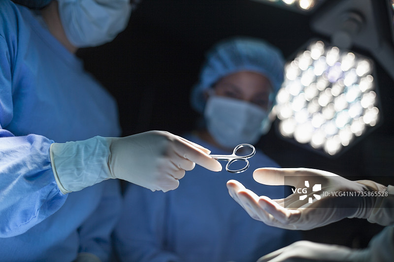 医务人员在医院手术室中传递手术工具图片素材