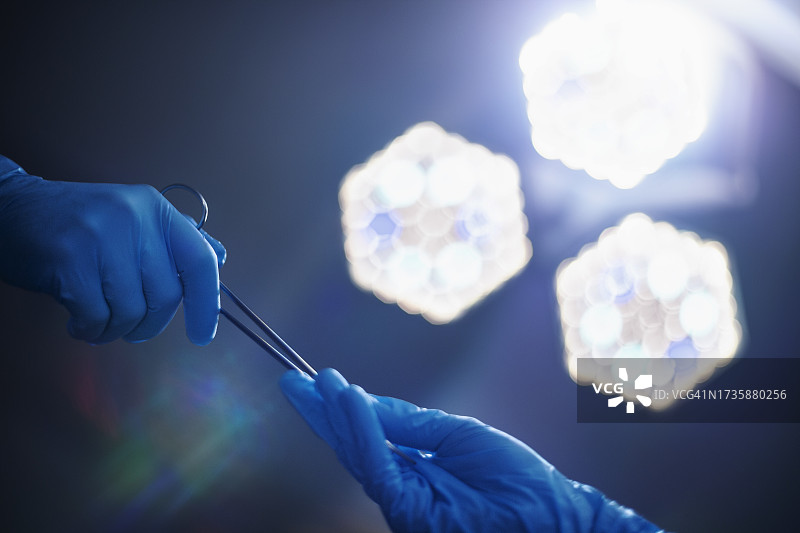 医疗专业人员在手术室中传递手术工具图片素材