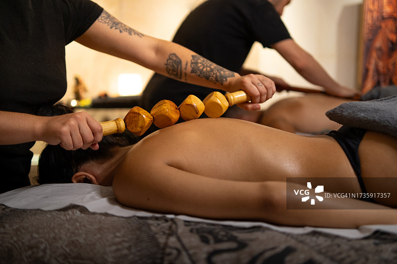 在豪华水疗中心接受木背按摩的人图片素材