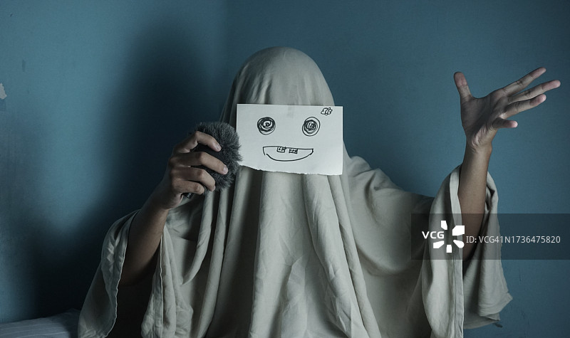 万圣节：友好的幽灵试图快乐地唱歌图片素材