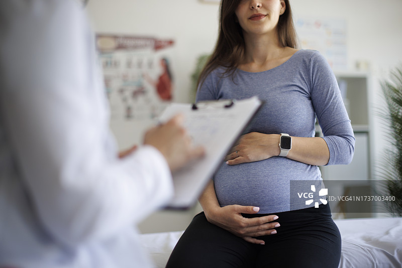 医生在医院与怀孕患者一起检查文件图片素材