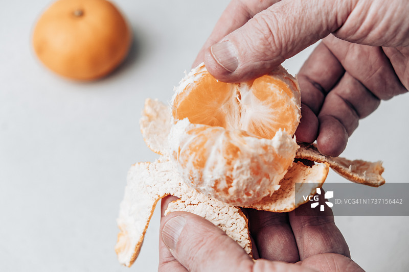 男人剥橘子的手部特写图片素材