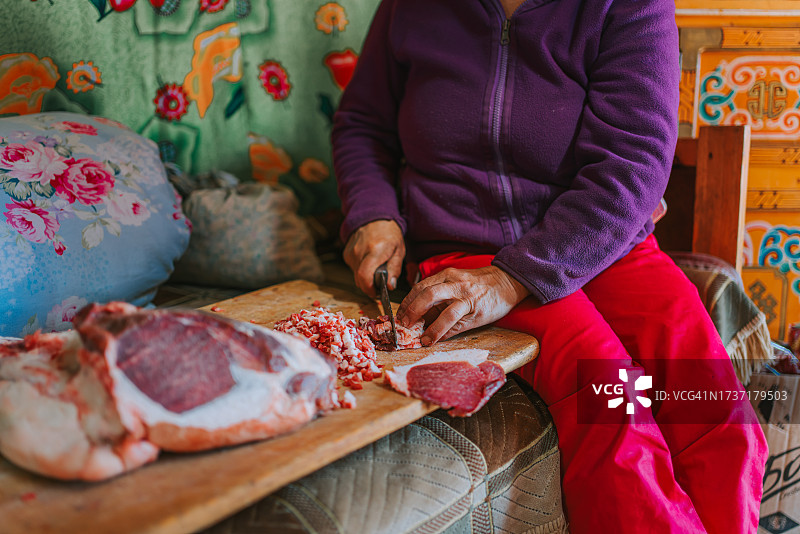 蒙古族妇女正在切羊肉准备包子图片素材