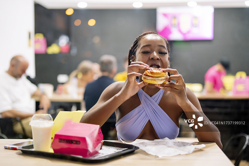 在汉堡餐厅里的黑皮肤女人图片素材