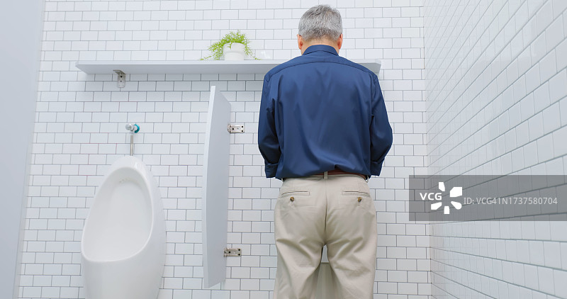 男人使用小便池图片素材