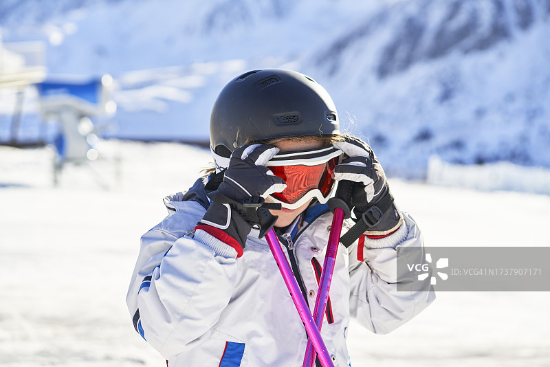 雪地里调整滑雪镜的女孩肖像（正面）图片素材