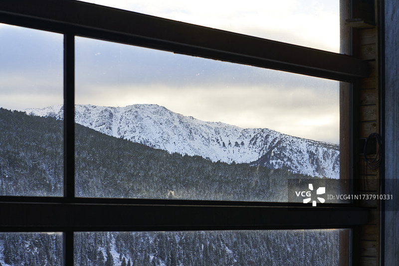 从房屋或小屋内透过窗户看到的雪山景观（正面视角）图片素材