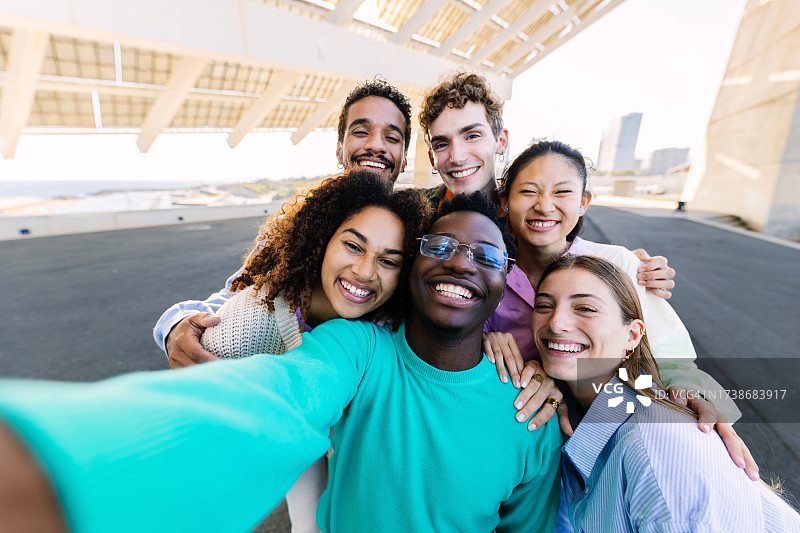 年轻快乐的大学生朋友在户外合影，在城市街道享受生活图片素材