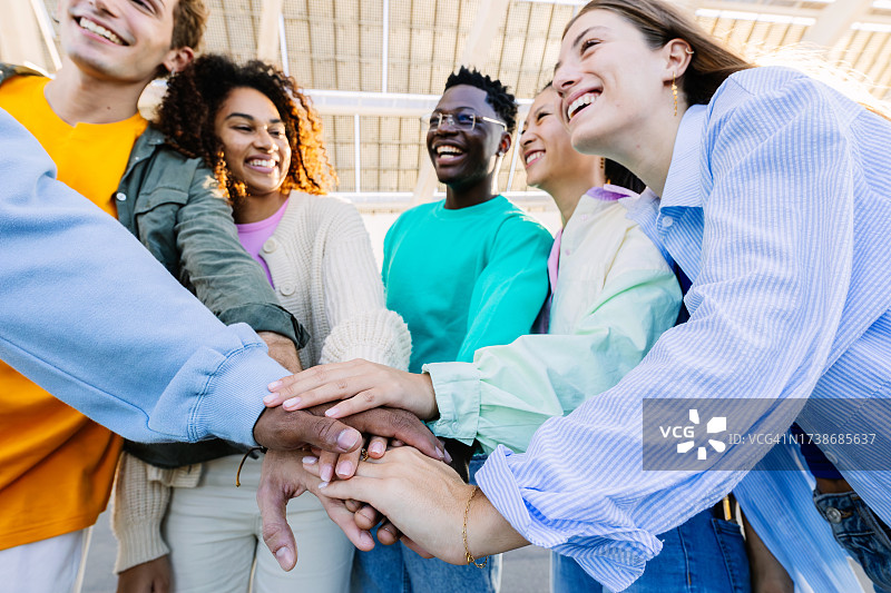 多元种族年轻大学生户外叠手展示团结图片素材