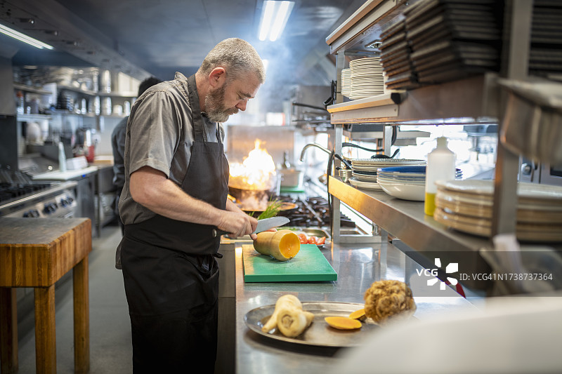 厨师在餐厅厨房切菜图片素材