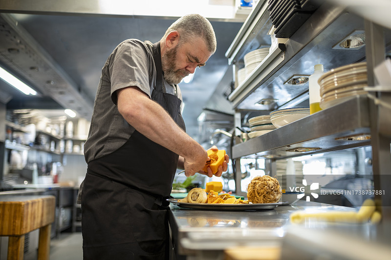 厨师在餐厅厨房切菜图片素材