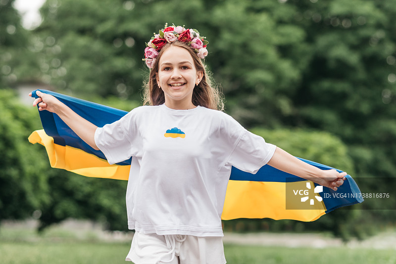 穿乌克兰刺绣衬衫的女孩，手持乌克兰国旗图片素材