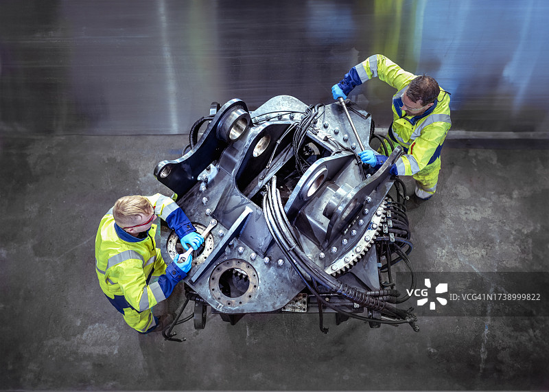维修工厂内工程师拧紧大型工程部件螺栓图片素材