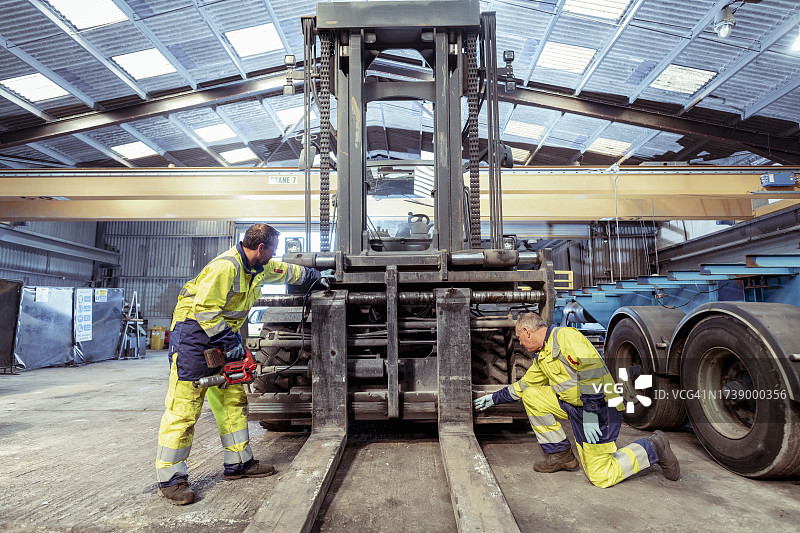 在工程维修厂检查叉车的工程师图片素材