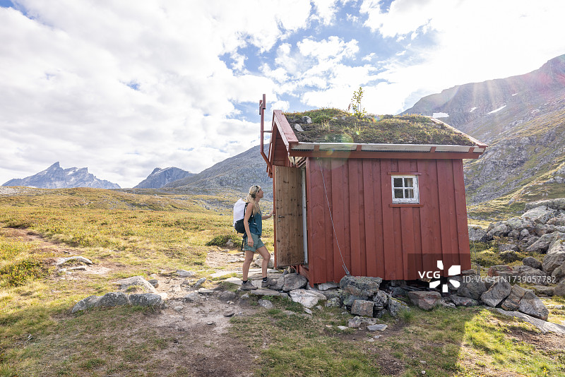 年轻女人进入山间小屋图片素材