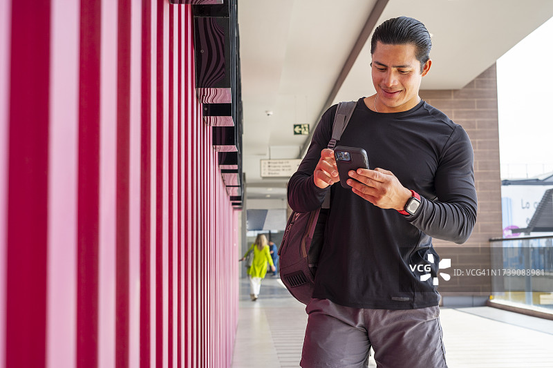 健身教练锻炼结束后在健身房与朋友用手机交谈图片素材