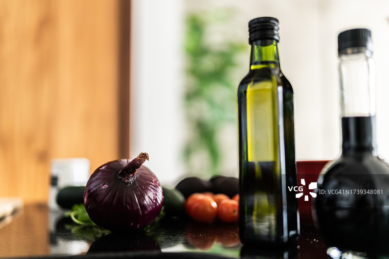 红洋葱和橄榄油在厨房台面上特写图片素材