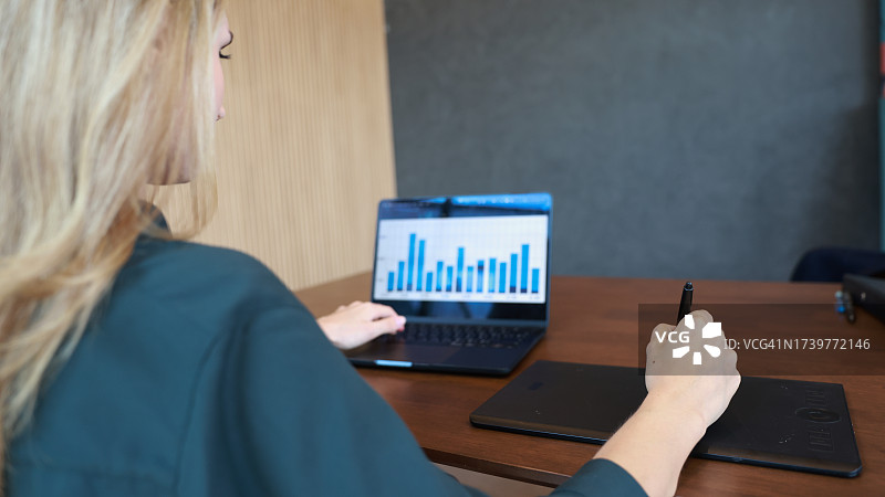 女职员在会议室使用数位笔和数位板在笔记本上工作图片素材