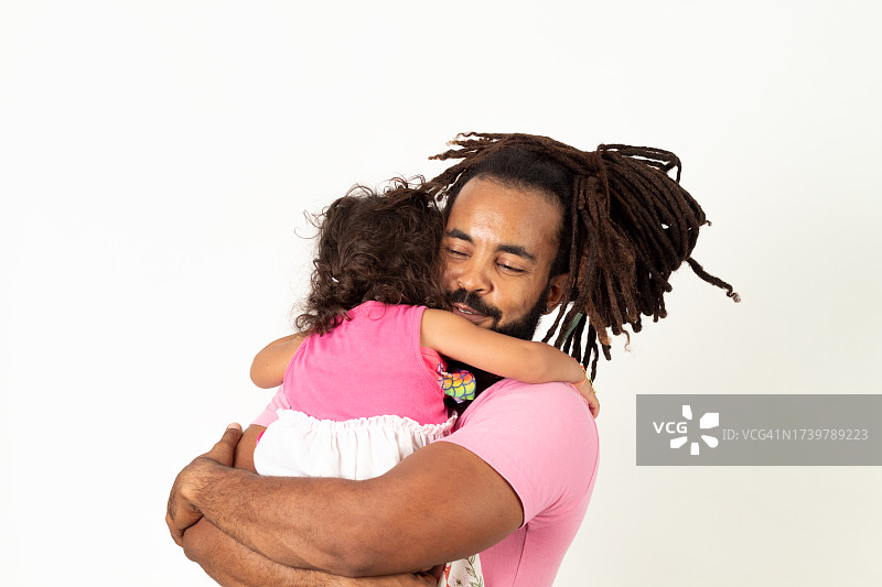 在白色背景下快乐地拥抱女儿的拉美父亲图片素材