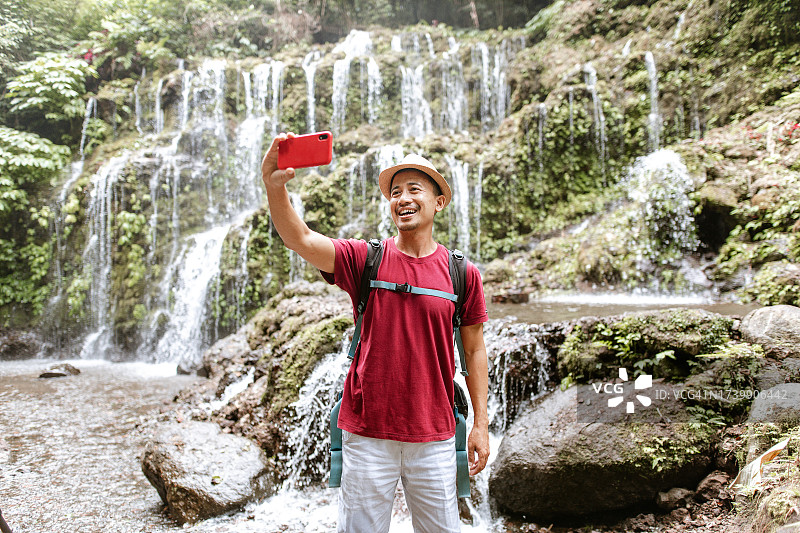 印尼游客游览巴厘岛美丽瀑布图片素材