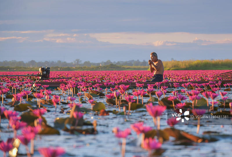 在泰国乌隆他尼红莲湖（Talay Bua Daeng）抽烟的渔民图片素材