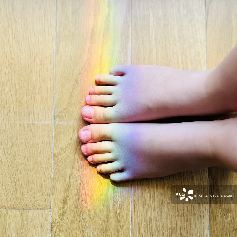 儿童脚上的彩虹光俯视图图片素材