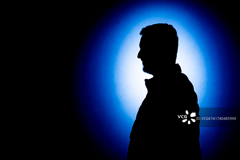蓝色背景下的年轻男人轮廓图片素材