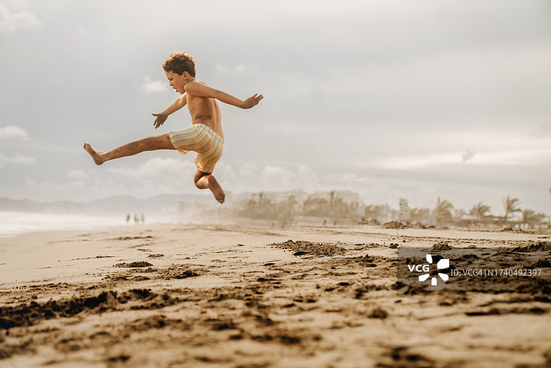 在海滩上跳跃的男孩们图片素材
