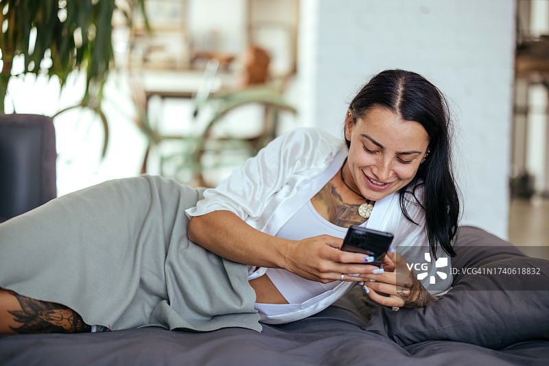女人早上在床上使用智能手机图片素材
