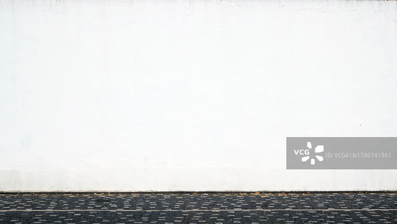 葡萄牙里斯本鹅卵石街道旁的白色混凝土墙图片素材