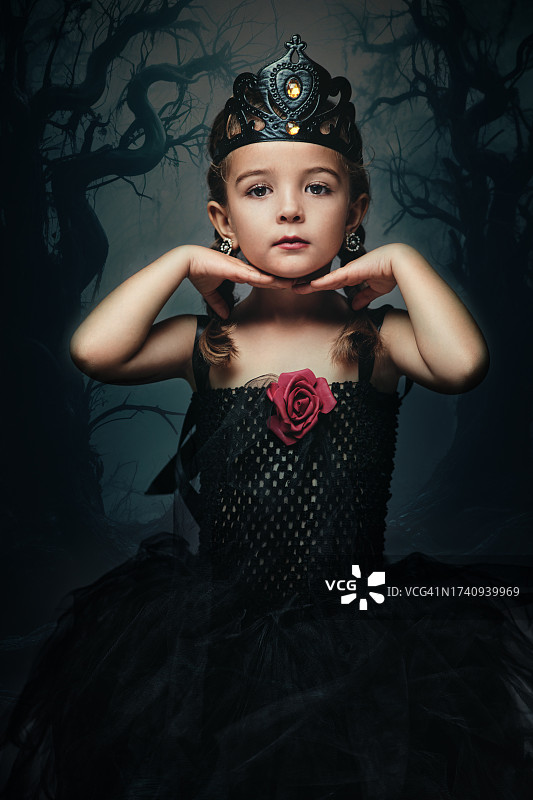 小女孩装扮成睡美人中的魔女玛琳菲森，双手托着下巴图片素材