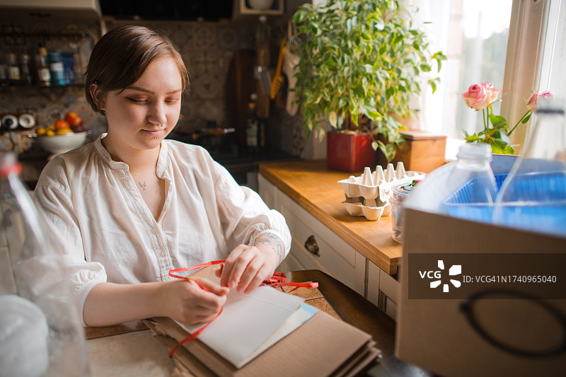 年轻女子在家中进行垃圾分类。可持续生活方式和垃圾回收概念图片素材