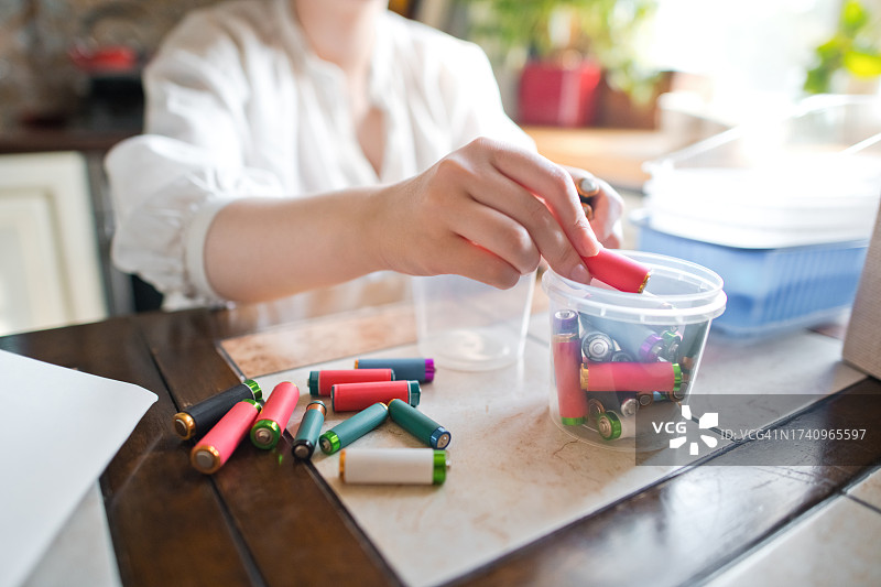 年轻女子在家中进行垃圾分类。可持续生活方式和垃圾回收概念图片素材