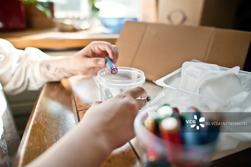 年轻女子在家中进行垃圾分类。可持续生活方式和垃圾回收概念图片素材