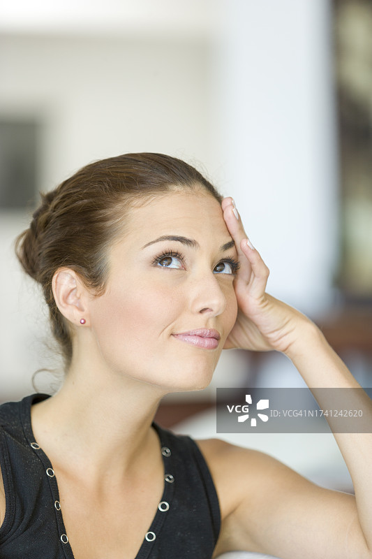 棕色头发的年轻女子托着头图片素材