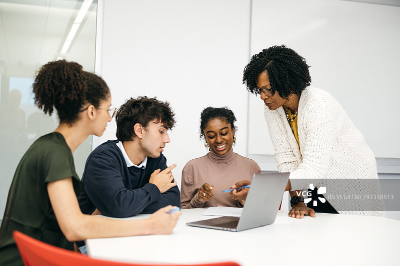 老师在教室里辅导大学生图片素材