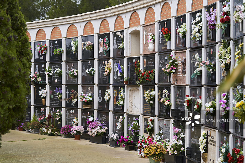 阳光明媚的墓地墙壁墓穴与装饰花卉（侧视图，无人）图片素材