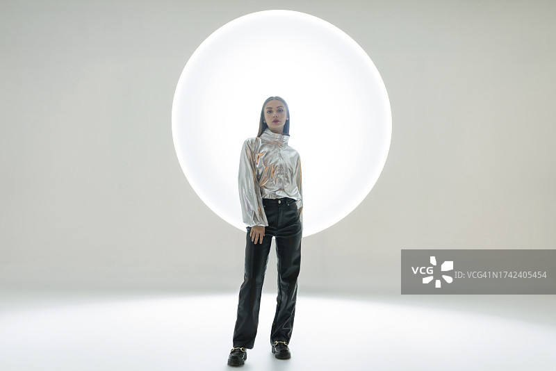 圆形灯光前的年轻女人图片素材