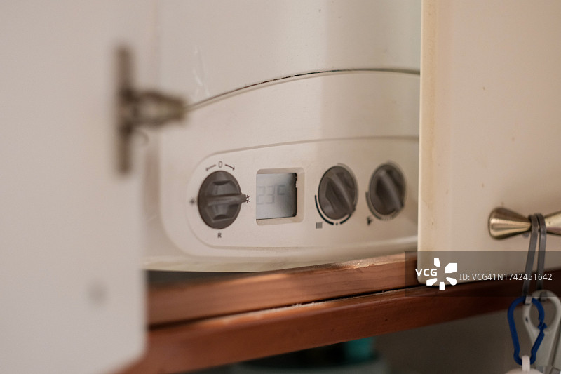 打开家中的燃气锅炉，调节温度图片素材