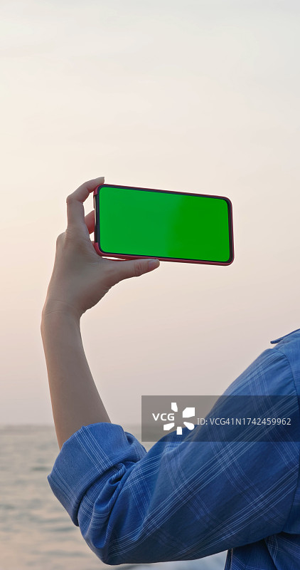 拿着带绿幕手机的女人图片素材