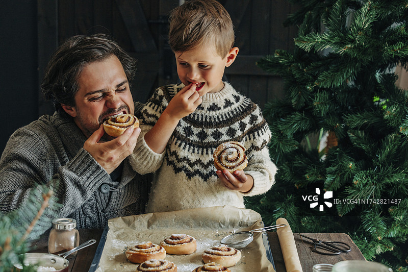 父子在餐桌旁吃肉桂卷图片素材