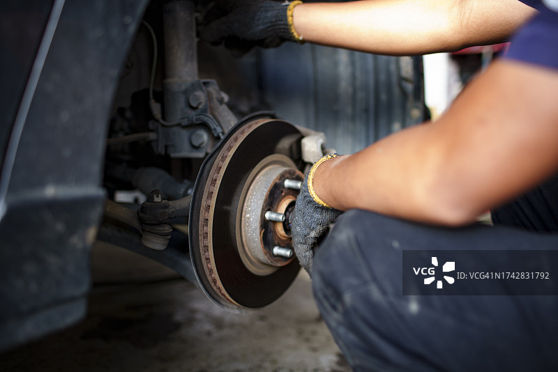 熟练技工在汽车修理厂更换汽车轮胎图片素材