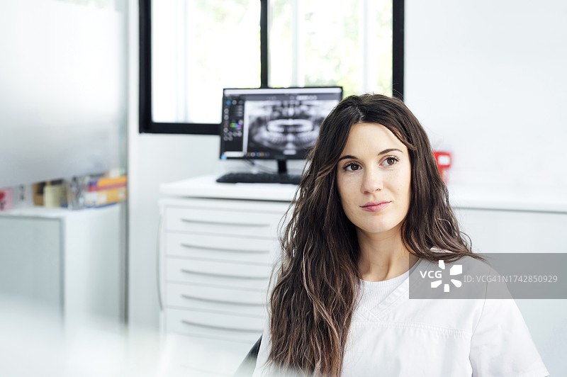 坐在牙科诊所里沉思的年轻牙医图片素材