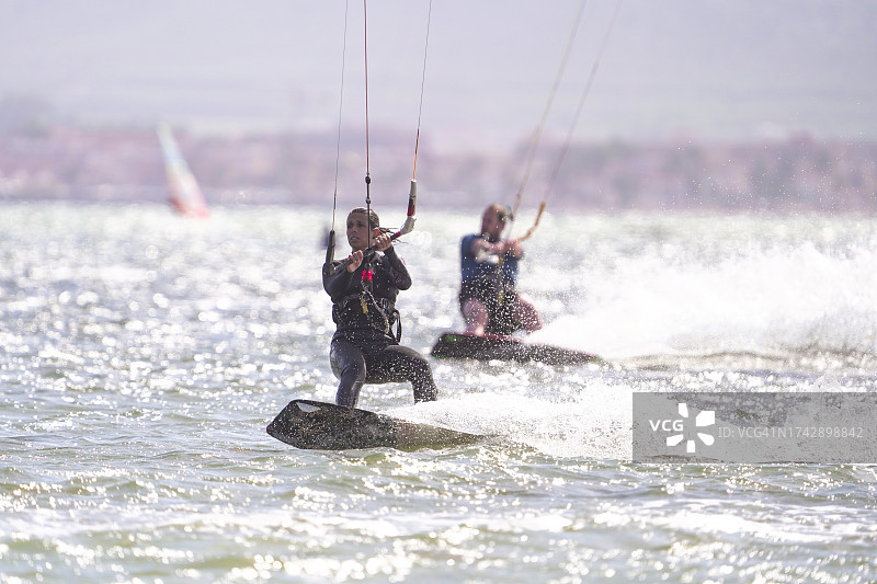 运动女人在阳光明媚的日子里在海上玩风筝板图片素材