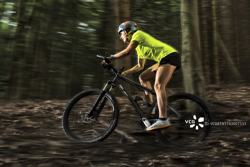 在森林中骑山地自行车的运动员图片素材