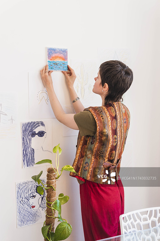 艺术家在墙上挂画图片素材