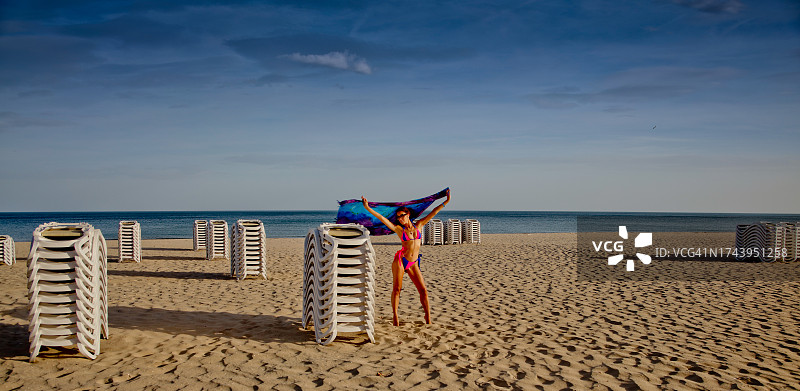 在海滩上拿着围巾的女人图片素材