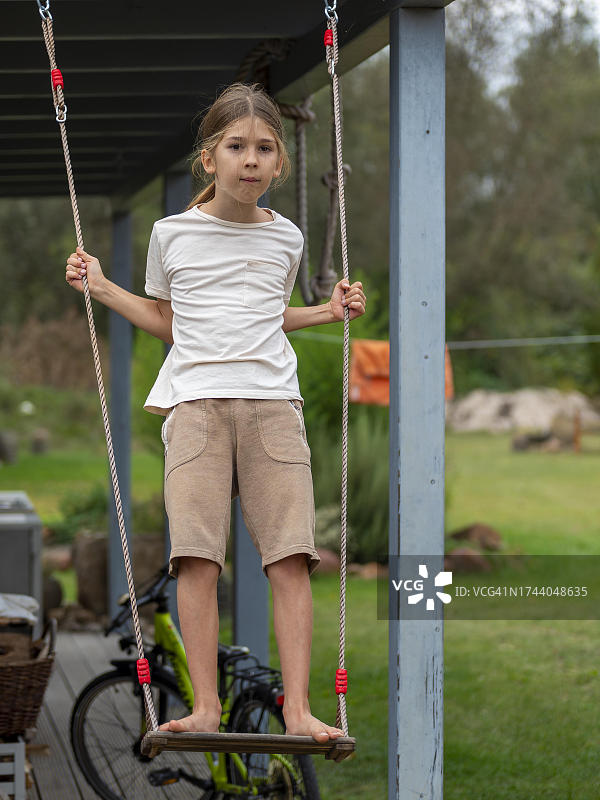 德国：男孩在棚屋旁的秋千上玩耍图片素材