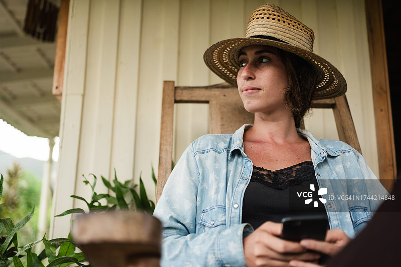 在拉丁美洲家中用手机的年轻女农民图片素材
